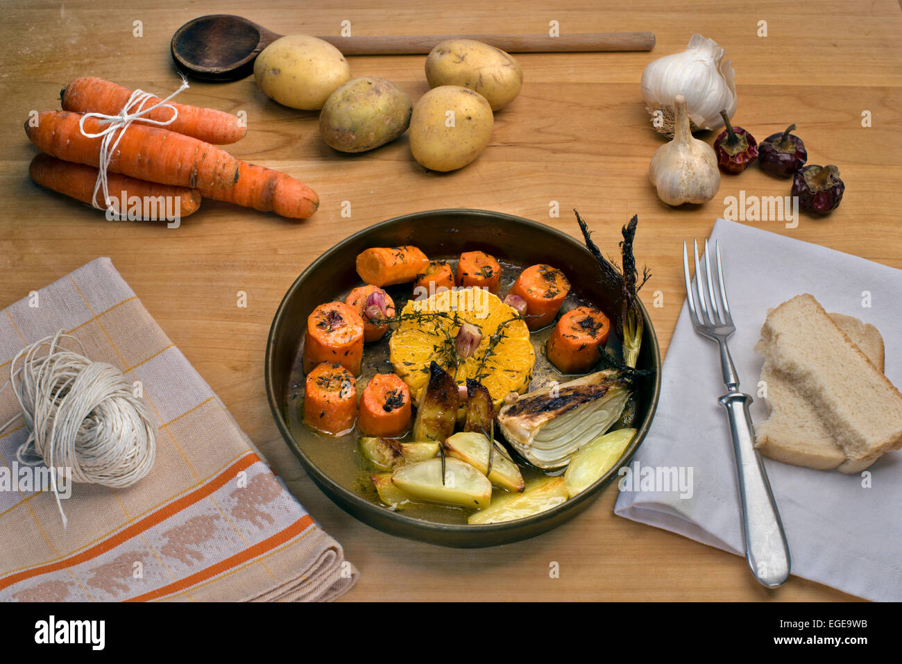 Karotten in Weißwein mit Orangen, Knoblauch, frischem Thymian und Butter gebraten serviert mit gebraten Rosmarinkartoffeln und Fenchel Stockfoto