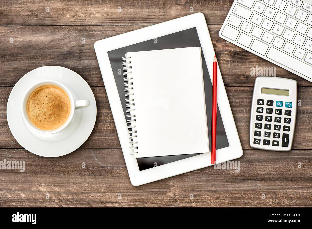 Home-Office Workstation. Arbeitsplatz mit digitalen Tablet-pc, Tastatur und Tasse Kaffee am Tisch aus Holz. Stockfoto