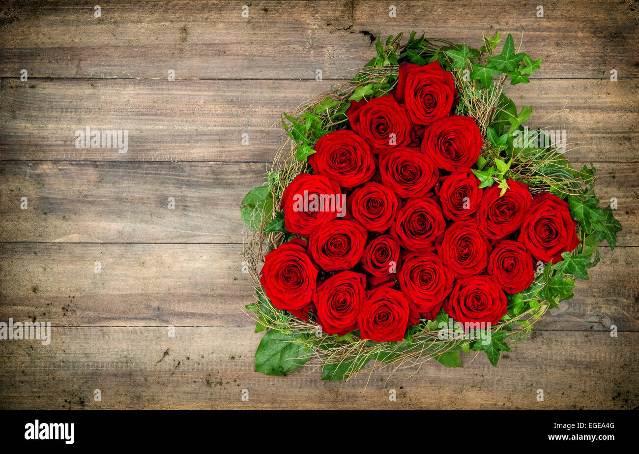 herzförmige rote Rosen auf rustikalen hölzernen Hintergrund. Valentinstag-Konzept. Retro-Stil Grunge getönten Bild Stockfoto