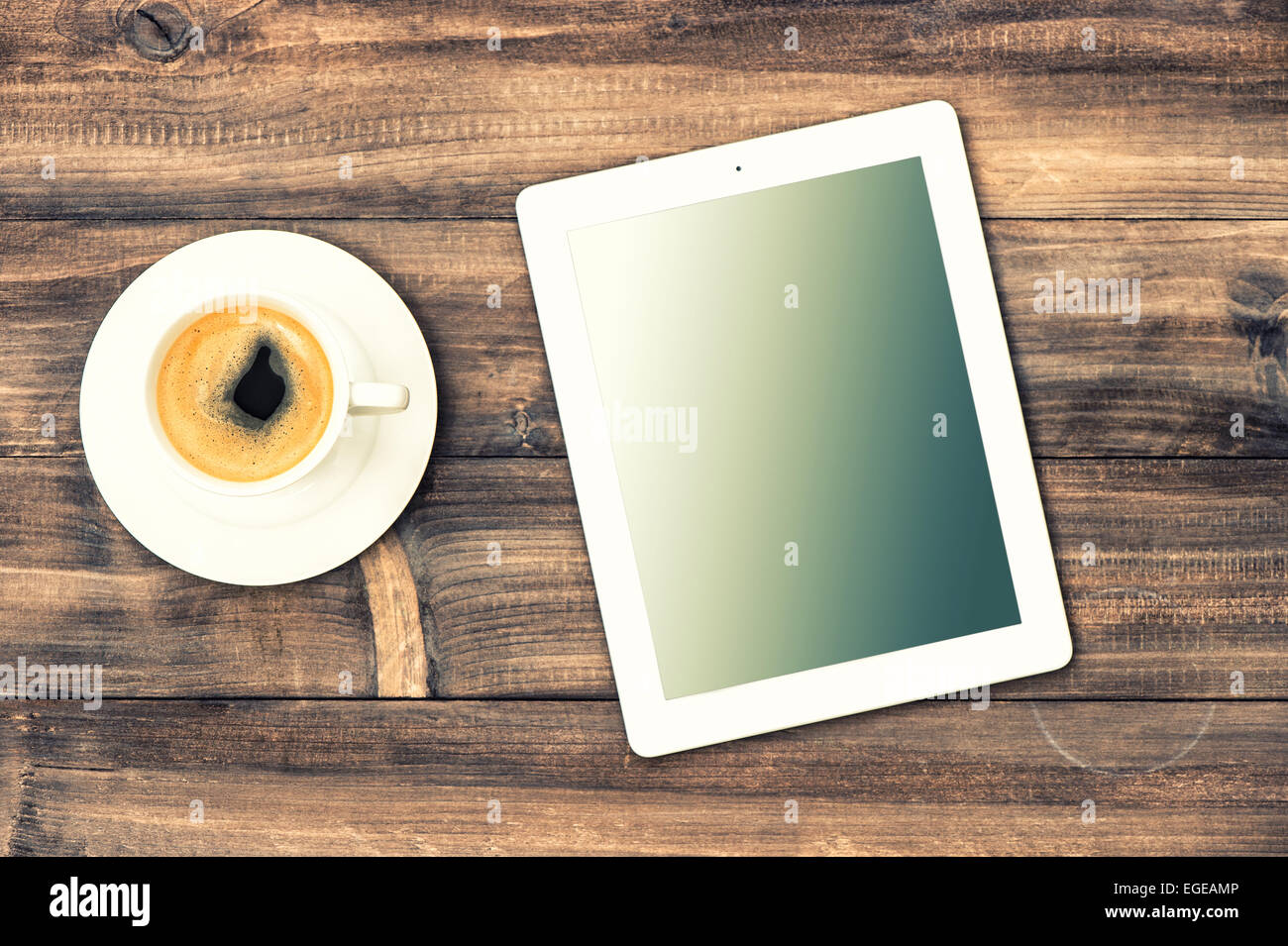 TabletPC und Kaffee am Schreibtisch aus Holz. Bearbeitungsstation mock-up im Stil von Instagram Stockfoto