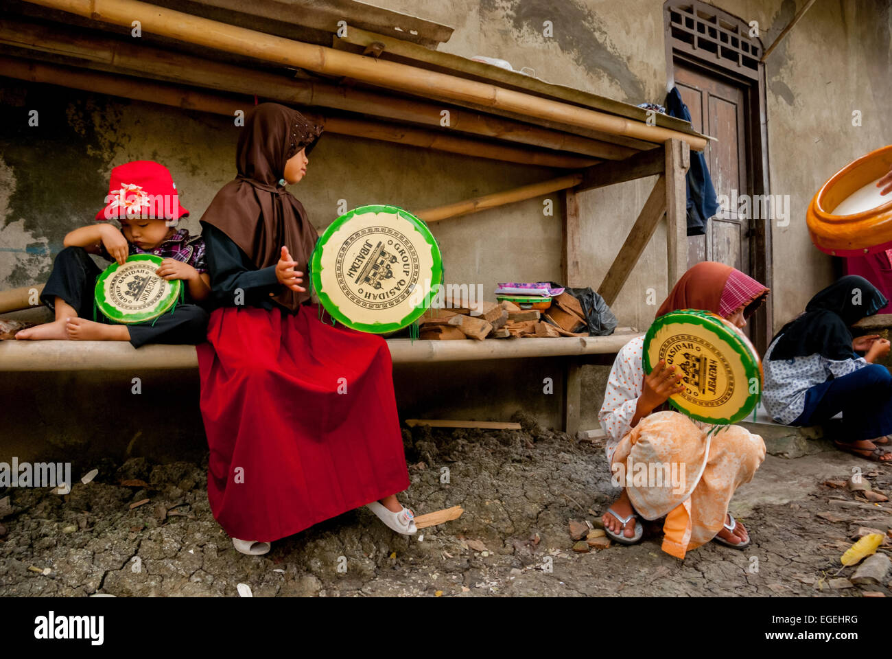 Eine Gruppe von Kindern auf dem Land, die rebana spielen, während sie sich für eine islamische Musikszene in Buni, Bekasi, West Java, Indonesien ausbilden. Stockfoto