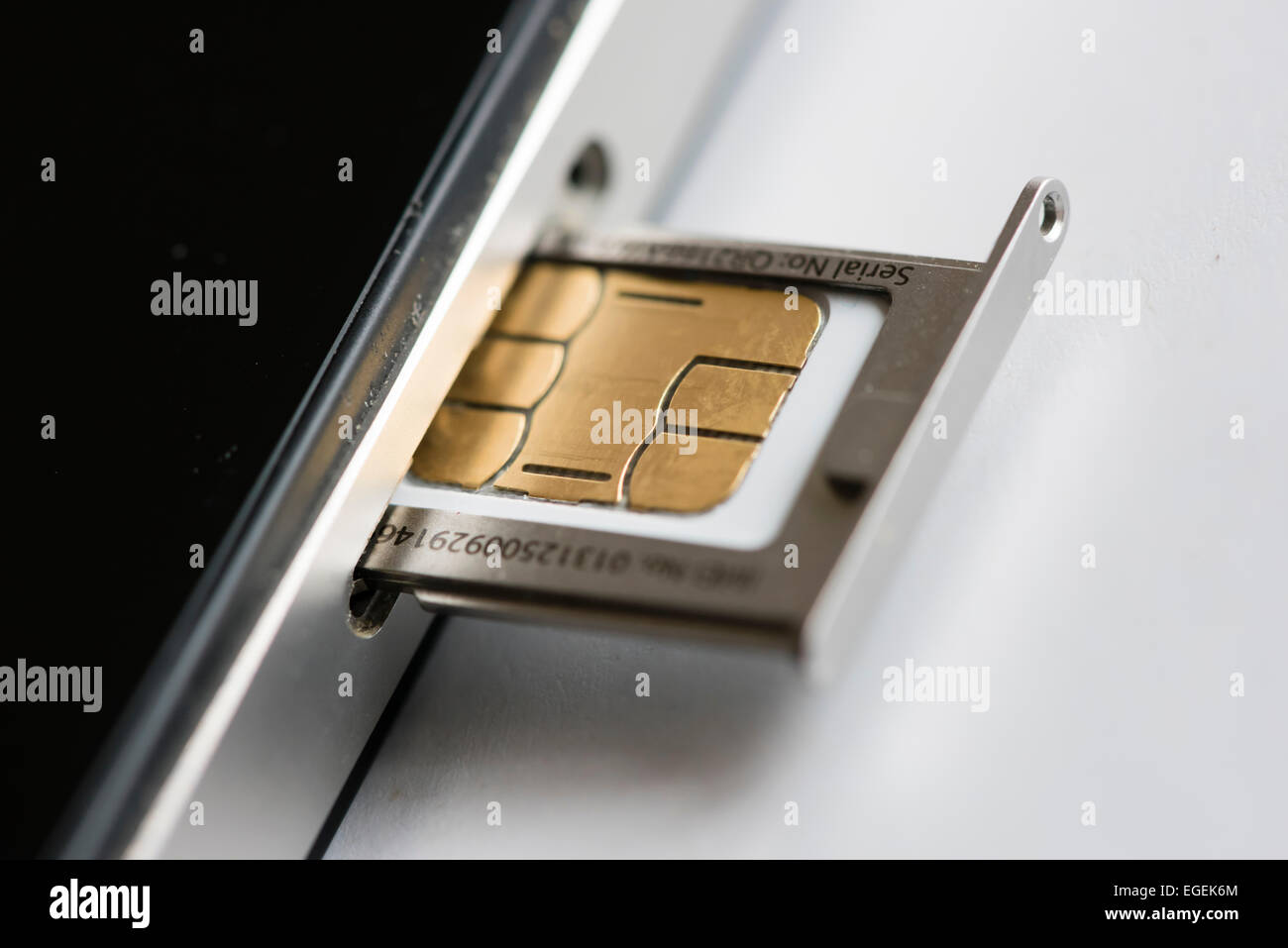 Eine micro SIM-Karte wird in ein Apple Iphone 4 Smartphone eingefügt. Stockfoto
