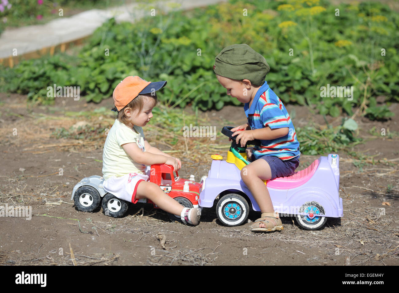 jungen und Mädchen auf Spielzeugautos in einen Unfall verwickelt Stockfoto