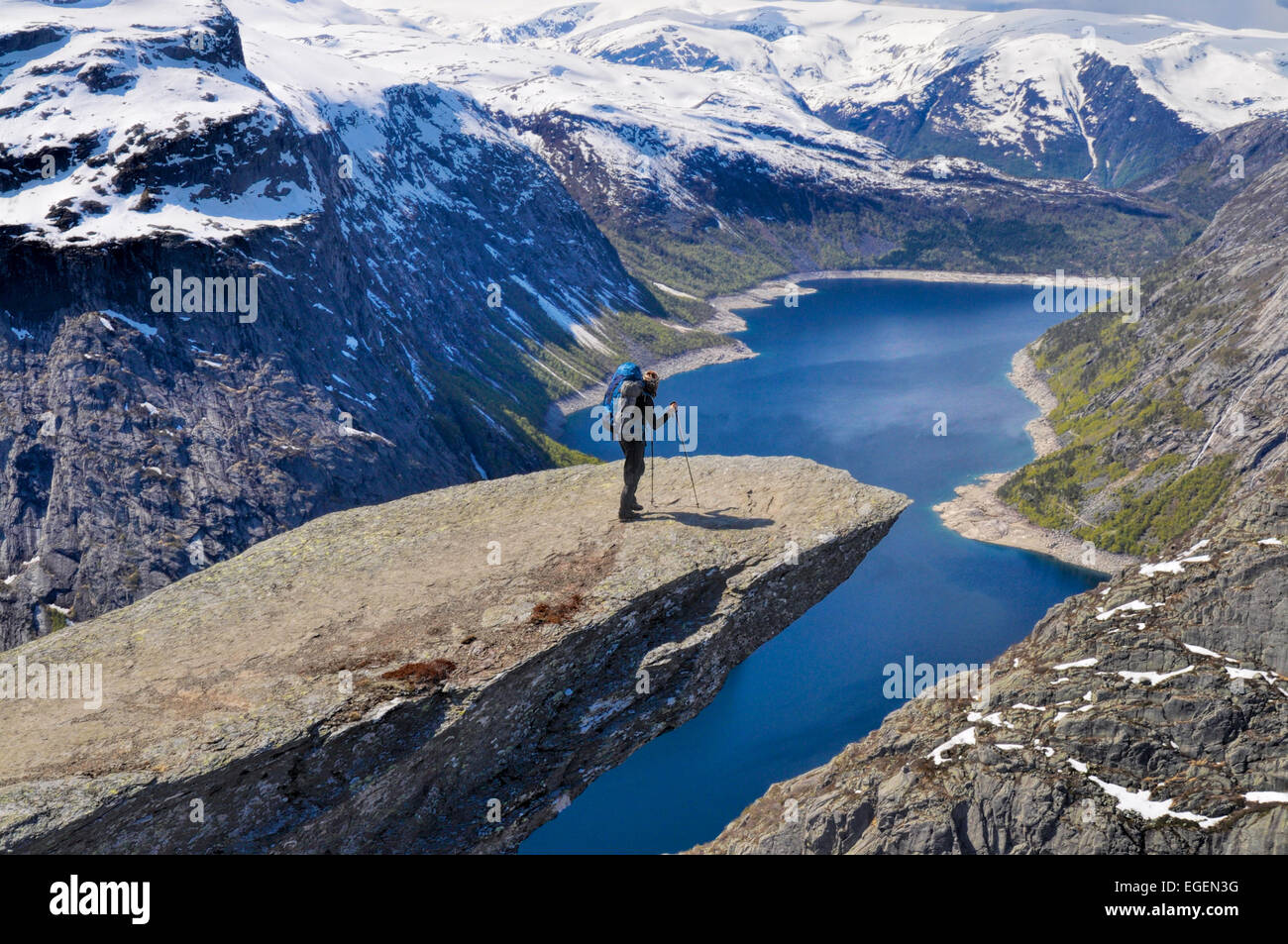 Wanderer mit Rucksack auf Trolltunga Felsen hoch über der malerischen Fjord in Norwegen Stockfoto