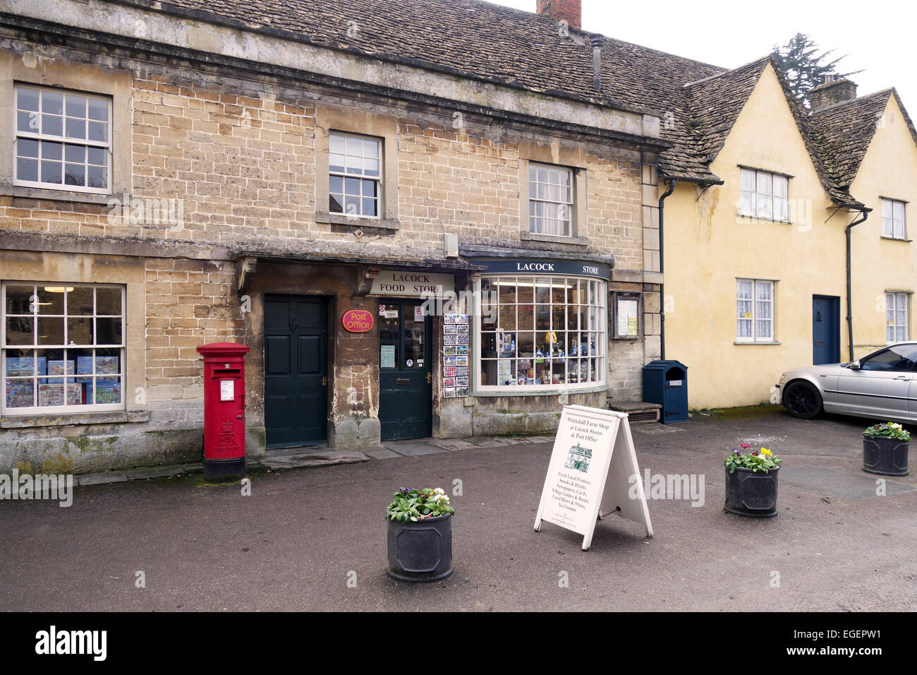 Village Post Office und Geschäfte in Lacock Village High Street, Lacock, Wiltshire mit traditionellem roten Briefkasten außerhalb, England, Großbritannien Stockfoto