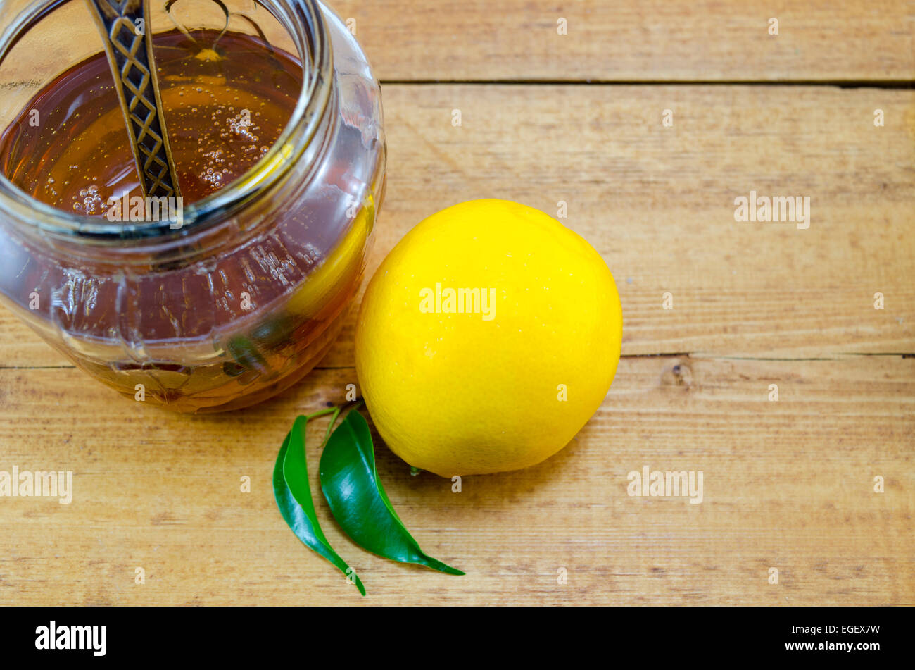 Ganze Zitrone und Honig in einem Glas auf einem Holztisch Stockfoto