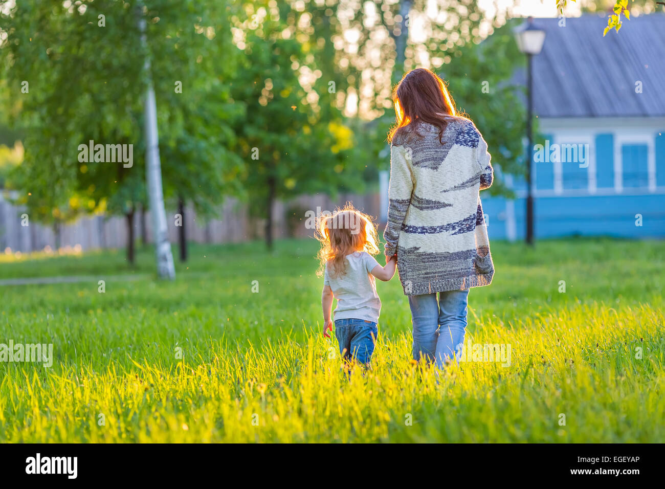 Mutter und Tochter zu Fuß in sonnigen park Stockfoto