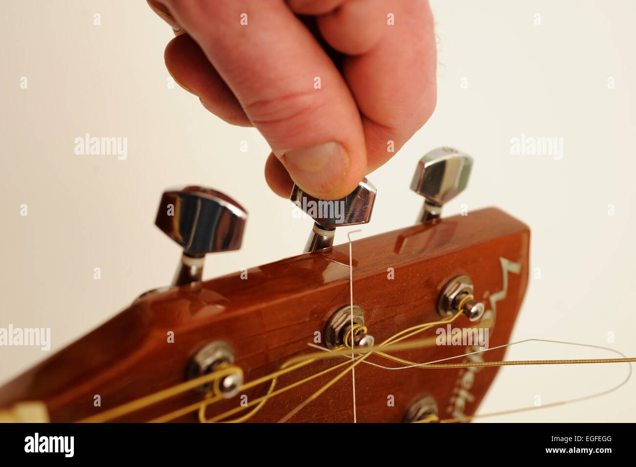 Männliche Hand Tunning einer akustischen Gitarre Stockfoto