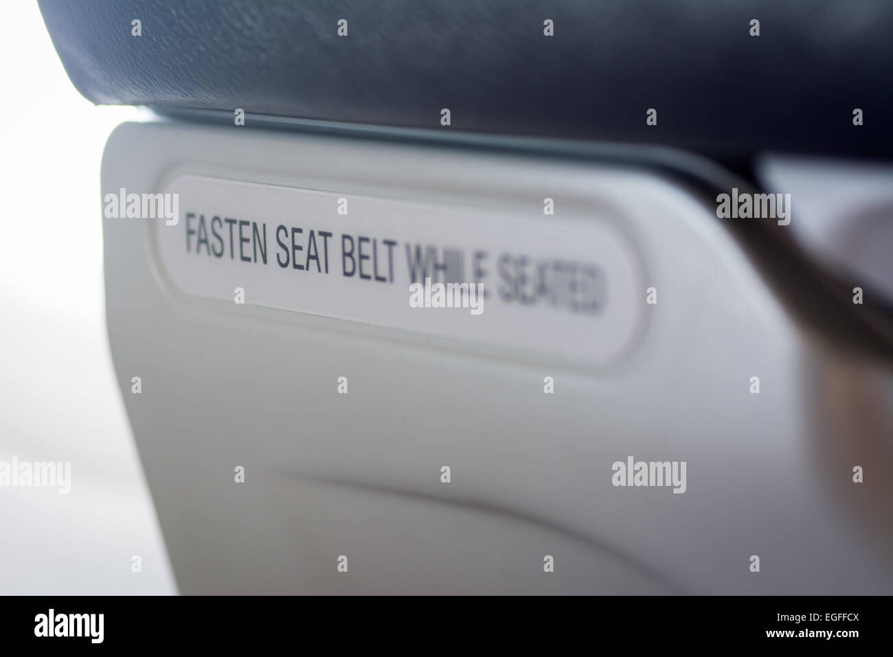 Befestigen Sie Sicherheitsgurt während sitzen Hinweis auf Rückseite des kommerziellen Flugzeugsitz Stockfoto