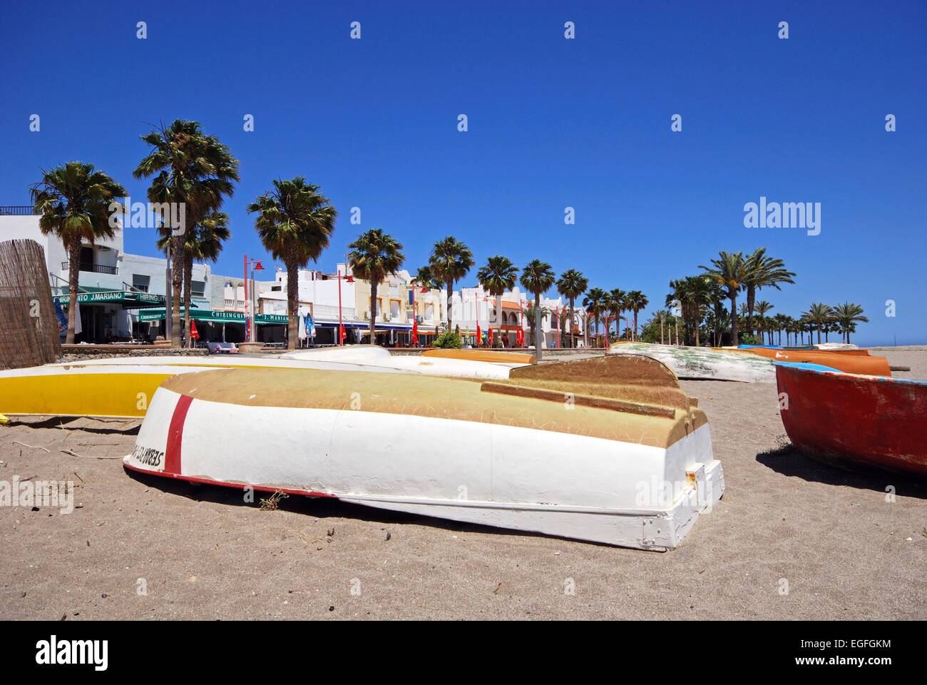 Umgedrehten Angelboote/Fischerboote am Strand mit Bars und Restaurants auf der Rückseite, Carboneras, Provinz Almeria, Costa Almeria, Spanien. Stockfoto