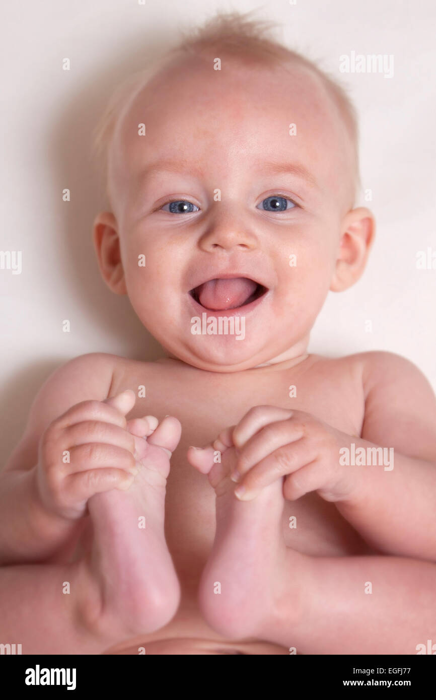 6 Monate altes Baby hält seine Zehen Stockfoto