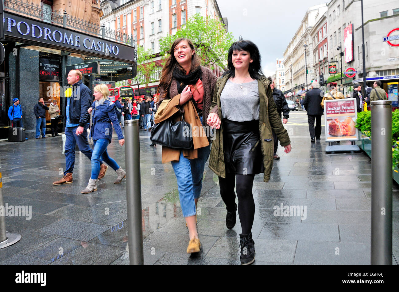 London, England, Vereinigtes Königreich. Zwei junge Frauen, die zu Fuß in Leicester Square Stockfoto