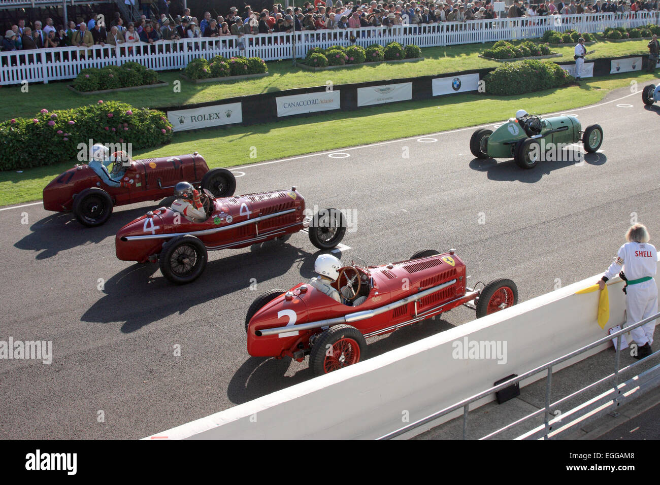 Ein köstliches Startraster mit Umberto Rossis hellrotem Alfa Romeo Tipo B aus dem Jahr 1934, Goodwood Revival, Großbritannien Stockfoto