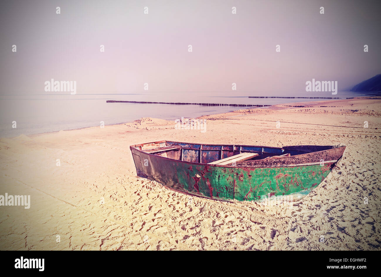 Alte Film Rückwirkung auf rostigem Stahl Boot am Strand. Stockfoto