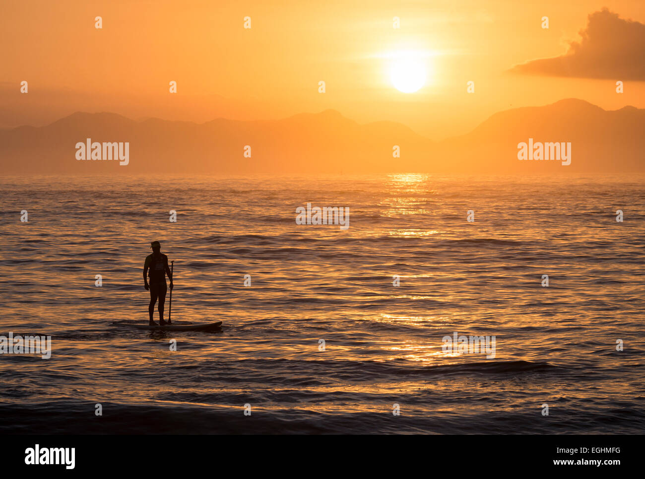 Mann-Paddle-boarding am Copacabana-Strand bei Sonnenaufgang Rio De Janeiro, Brasilien, Südamerika Stockfoto