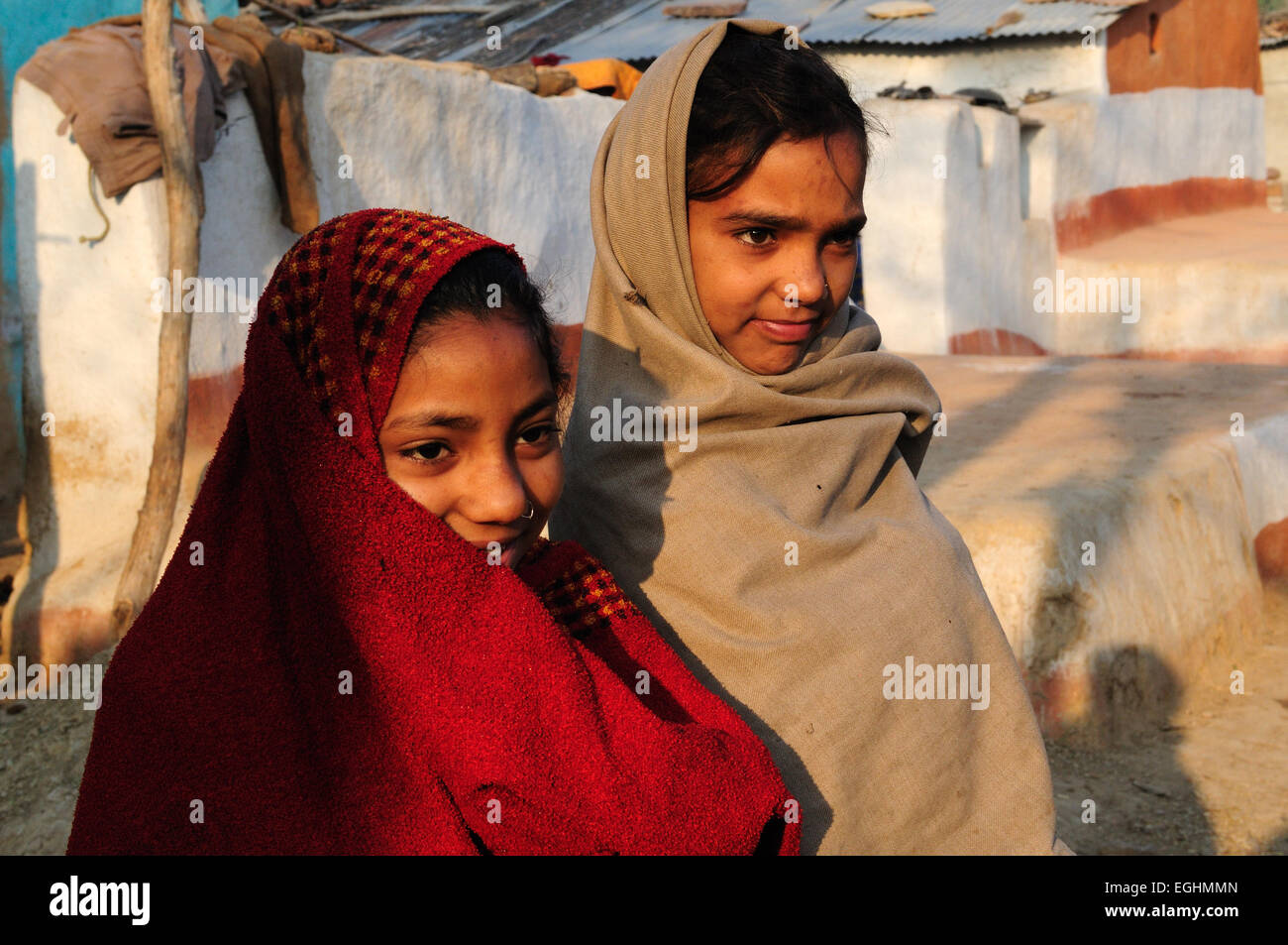 Zwei indische Mädchen eingewickelt in Decken in der kalten Morgenluft in ein Stammes-Dorf Madhya Pradesh, Indien Stockfoto