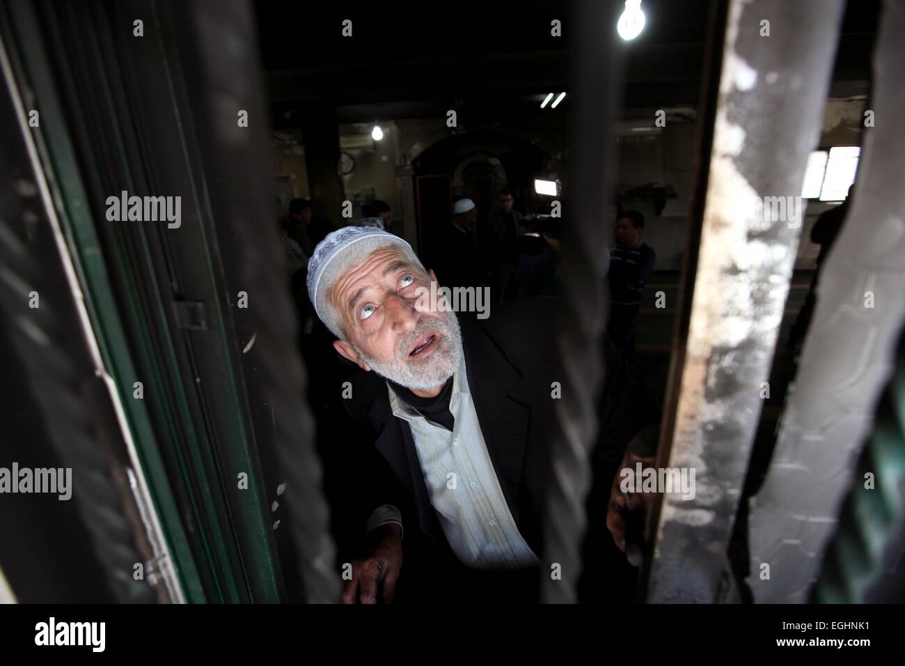 (150225)--BETHLEHEM, 25. Februar 2014 (Xinhua)--palästinensischer Imam Ibrahim Abu Luha inspiziert die Moschee, nachdem es über Nacht mit Anti-arabische Slogans auf Hebräisch an der Wand der Moschee von israelischen Siedlern in al-Jaba Dorf in der Nähe der West Bank von Bethlehem aufgesprüht 25. Februar 2015 in Brand gesteckt wurde. (Xinhua / Luay Sababa) (Azp) Stockfoto