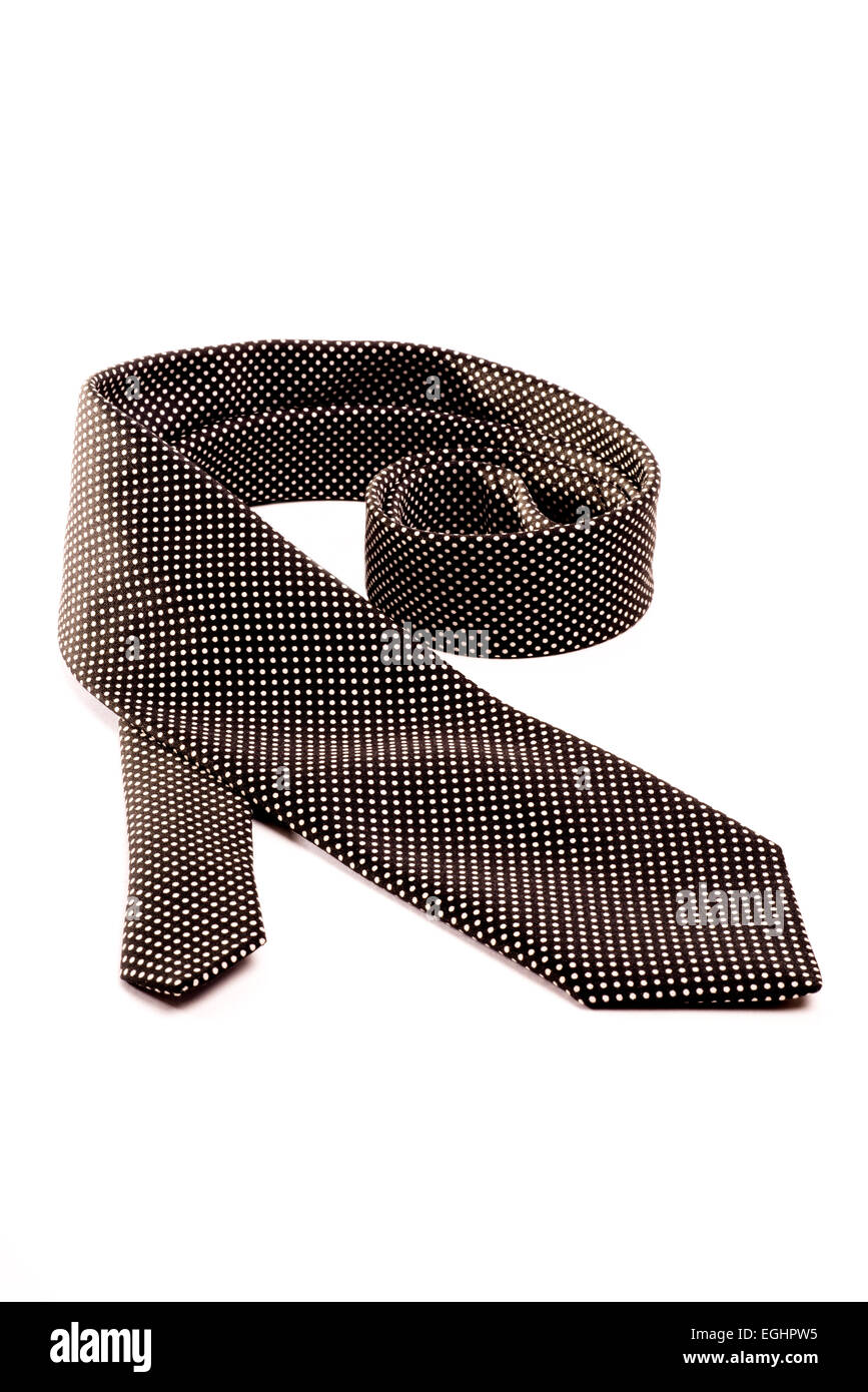 Eine schwarze Krawatte mit weißen Punkten auf einem weißen Hintergrund isoliert ausgerollt. Stockfoto