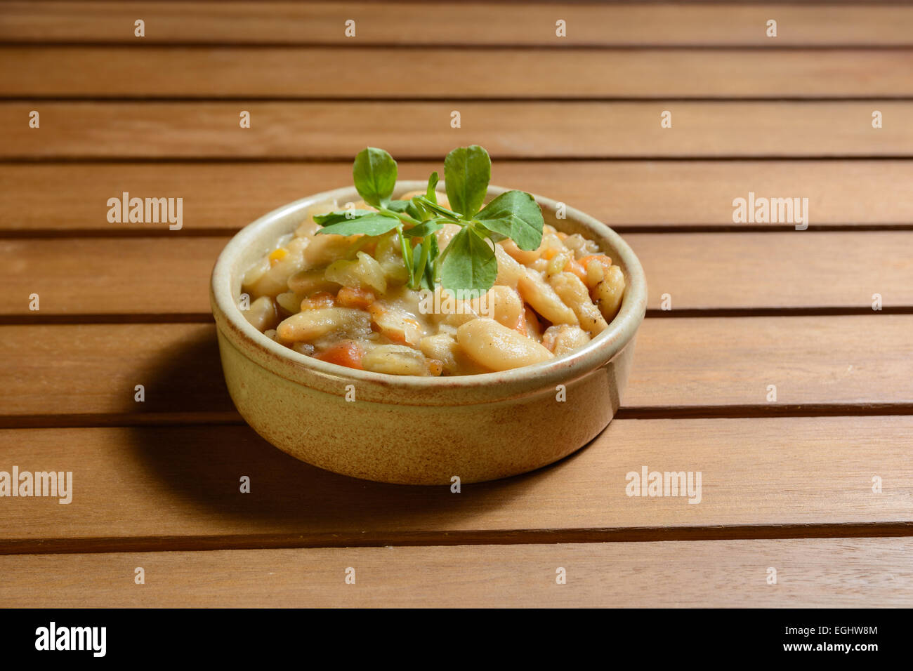 Pikante spanische Bohnen-Eintopf mit Gemüse in einer Schüssel braun Terra Cotta. Fabada Asturiana. Stockfoto