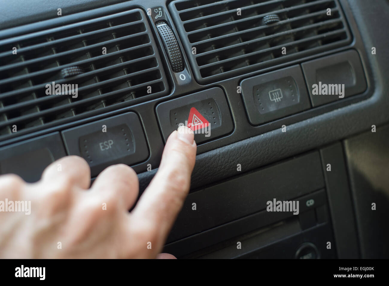Finger zu leichten Warnblinkschalter in einem Auto schieben Stockfoto