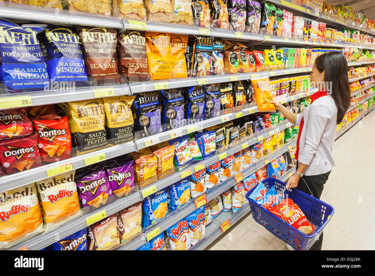 China, Hong Kong, Hausfrau Kauf importiert westlichen Junk-Food im Supermarkt Stockfoto