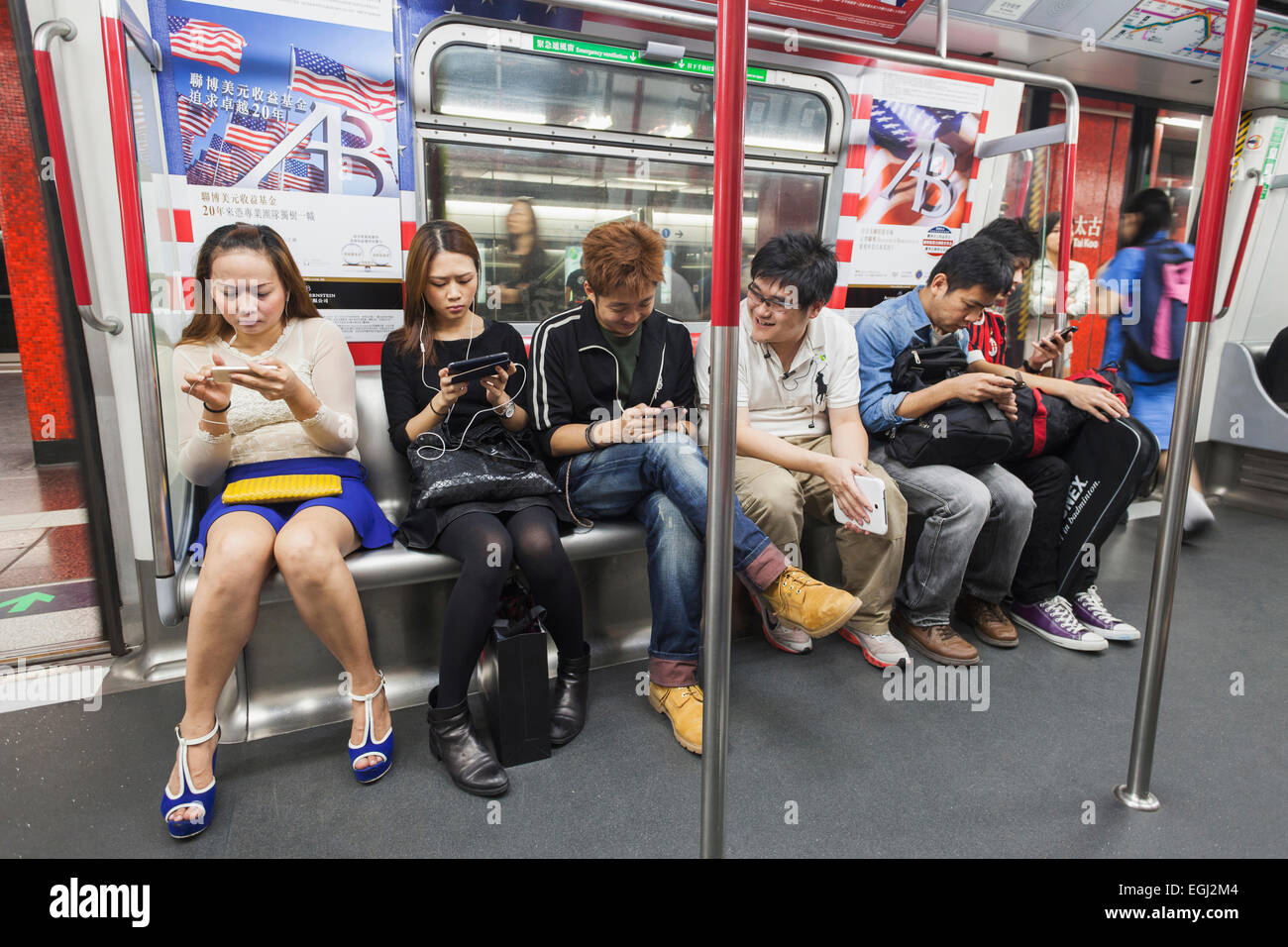 China, Hong Kong, U-Bahn Fahrgäste Verwendung elektronischer Geräte Stockfoto