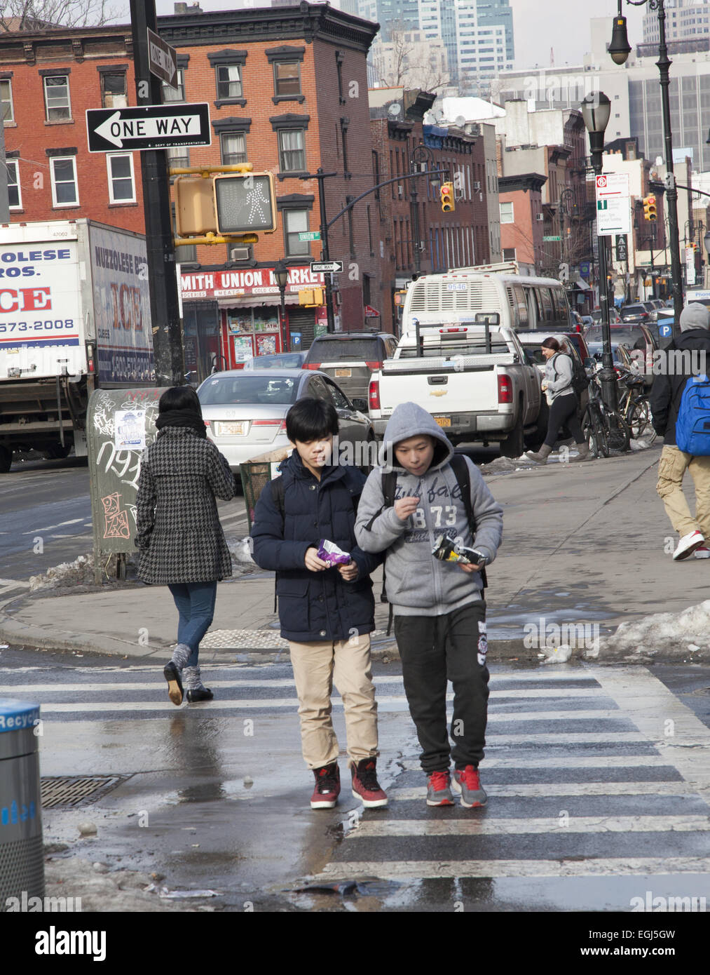 Pre-teen-Boys snack als sie nach Hause nach der Schule entlang Smith Street im Stadtteil Carroll Gardens of Brooklyn, NY gehen. Stockfoto