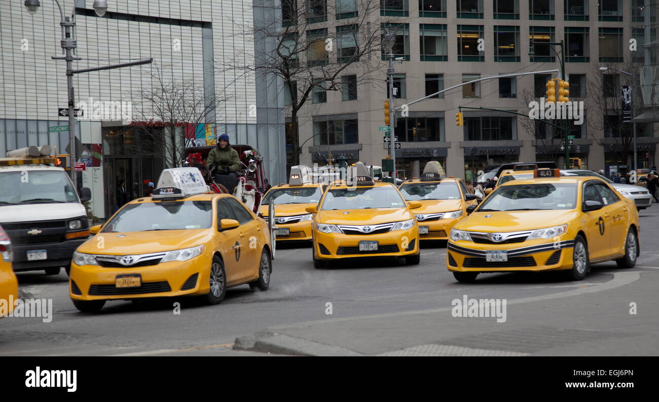 Eine Herde von Taxis und ein Pferd & Wagen herumfahren Columbus Circle und Broadway at South Central Park in Manhattan, NYC. Stockfoto