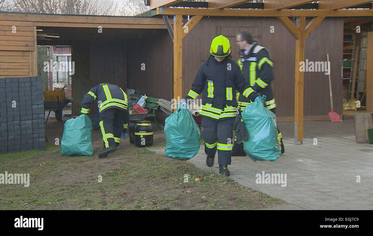 Feuerwehrleute tragen grüne Plastiktüten aus einem Garten Zuteilung in Preetz, Deutschland, 24. Februar 2015. Eine Dose Giftgas Zyklon B war auf die Zuteilung und gesichert durch ein Specilised Unternehmen, erklärte ein Sprecher der örtlichen Polizei. Die Ursprünge der Dose sind ab sofort noch unklar. Der Zustand Büro der kriminellen Untersuchung des Landes Schleswig-Holstein hat die Ermittlungen aufgenommen. Zyklon B ist ein giftiges Gas, das von den Nazis für die industrialisierten Ermordung von Primperaly europäischen Juden in Konzentrationslagern wie Auschwitz, während des Holocaust verwendet wurde. Foto: Daniel Friederichs/Dpa (ATTENTI Stockfoto