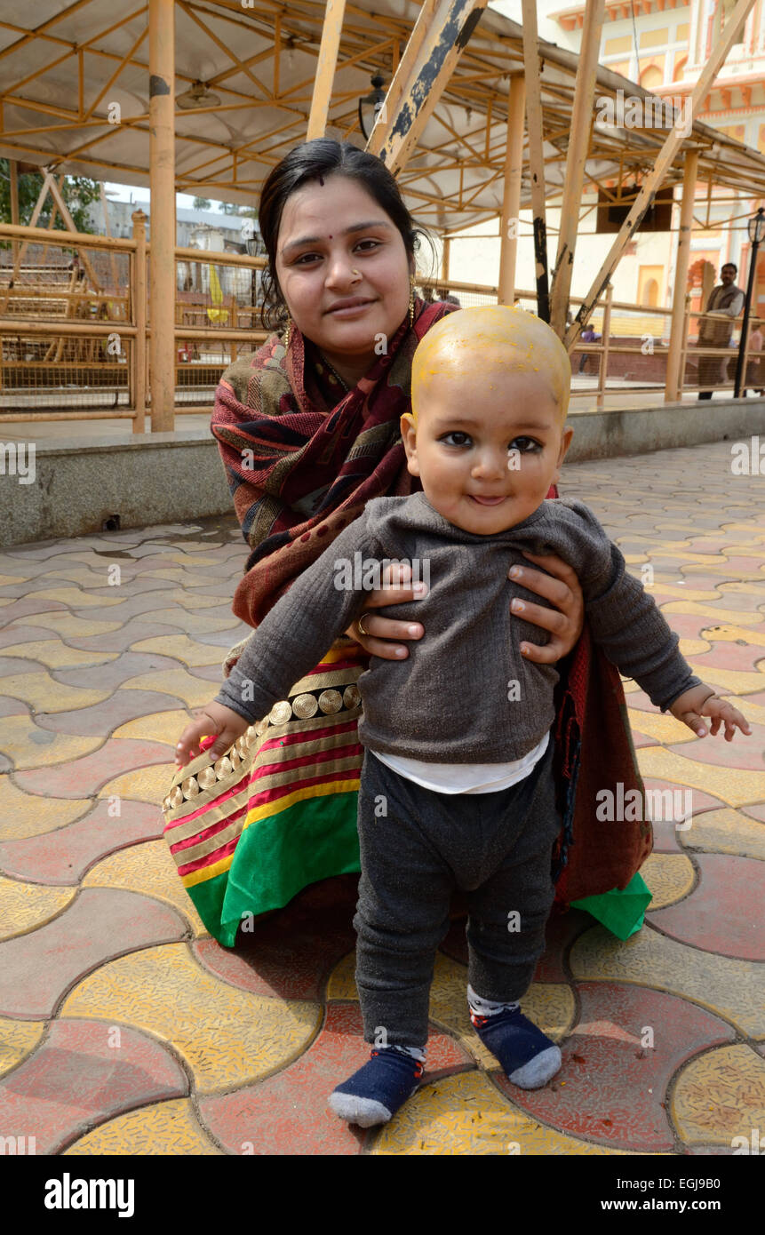 Eine indische Baby Boy mit seiner Mutter nach seinem Mundan oder den Kopf rasieren Zeremonie Ram Raja Tempels Orchha Madhya Pradesh, Indien Stockfoto