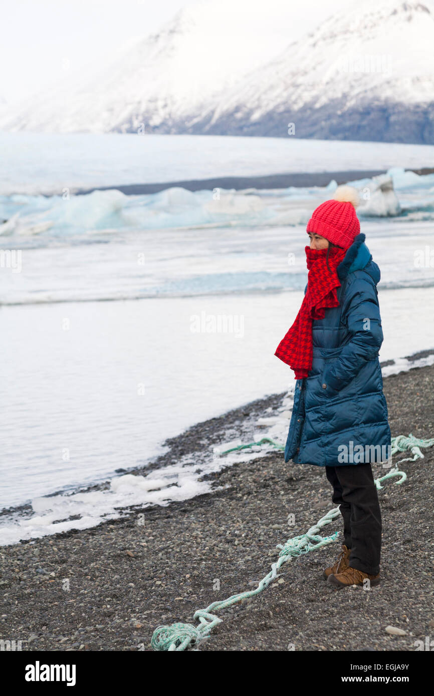 Touristin bewunderte im Februar die Ansichten der Jokulsarlon Glacial Lagoon, am Rande des Vatnajokull National Park, Island Stockfoto