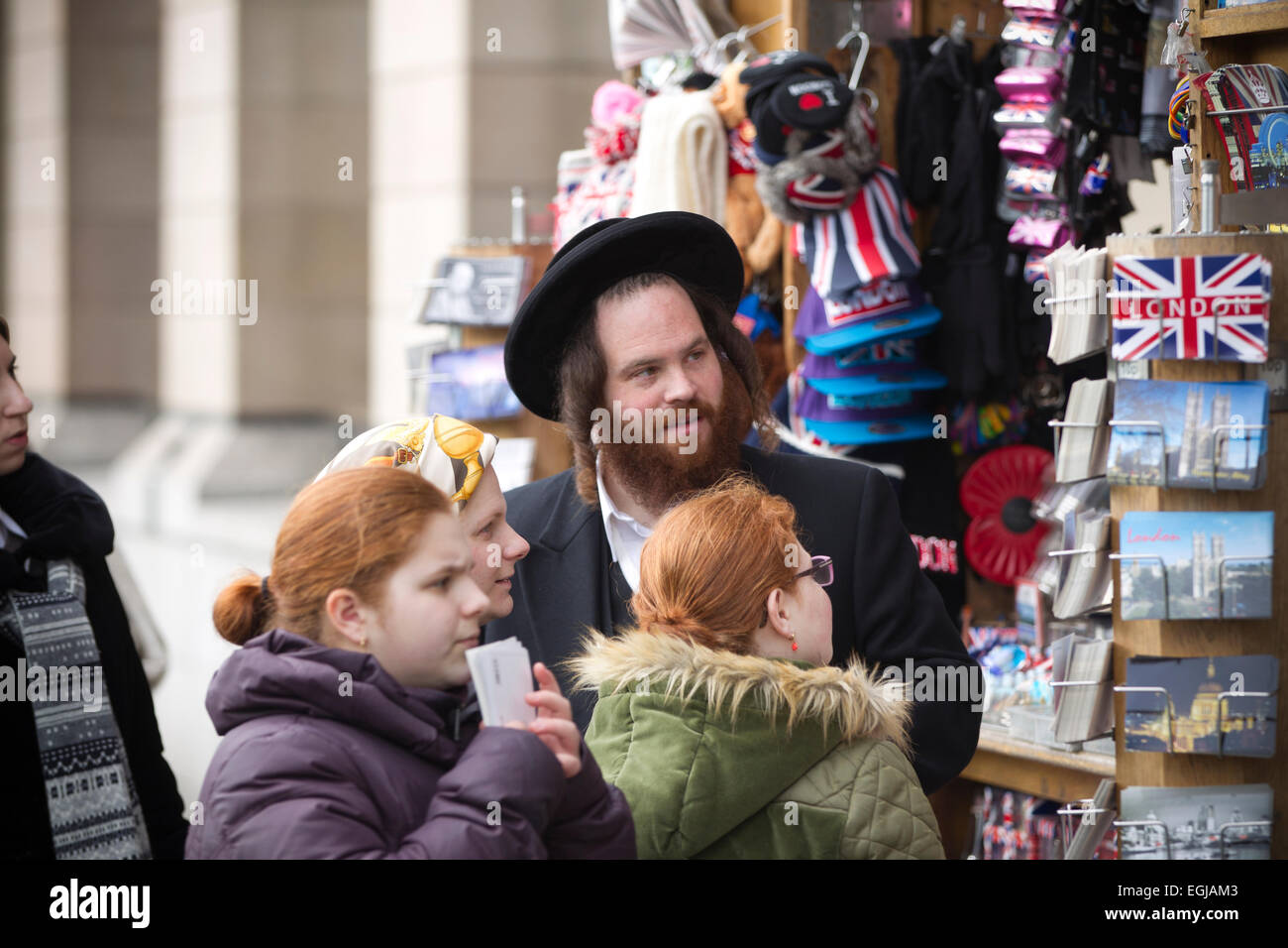 Jüdischen Touristen betrachten Postkarten aus London an einem Kiosk in Westminster, London, UK Stockfoto