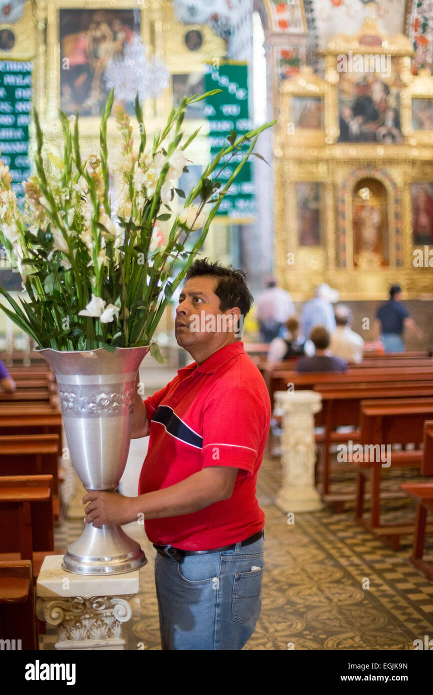 Tlacochahuaya, Oaxaca, Mexiko - Arbeiter legen Sie Blumen für eine Beerdigung in das Heiligtum der Kirche San Jeronimo. Stockfoto