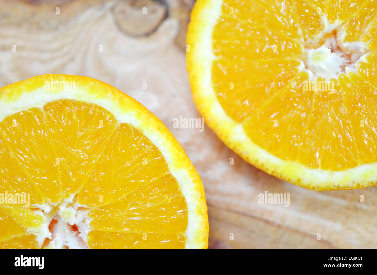 Zwei orange Hälften hautnah auf einem Brett Stockfoto