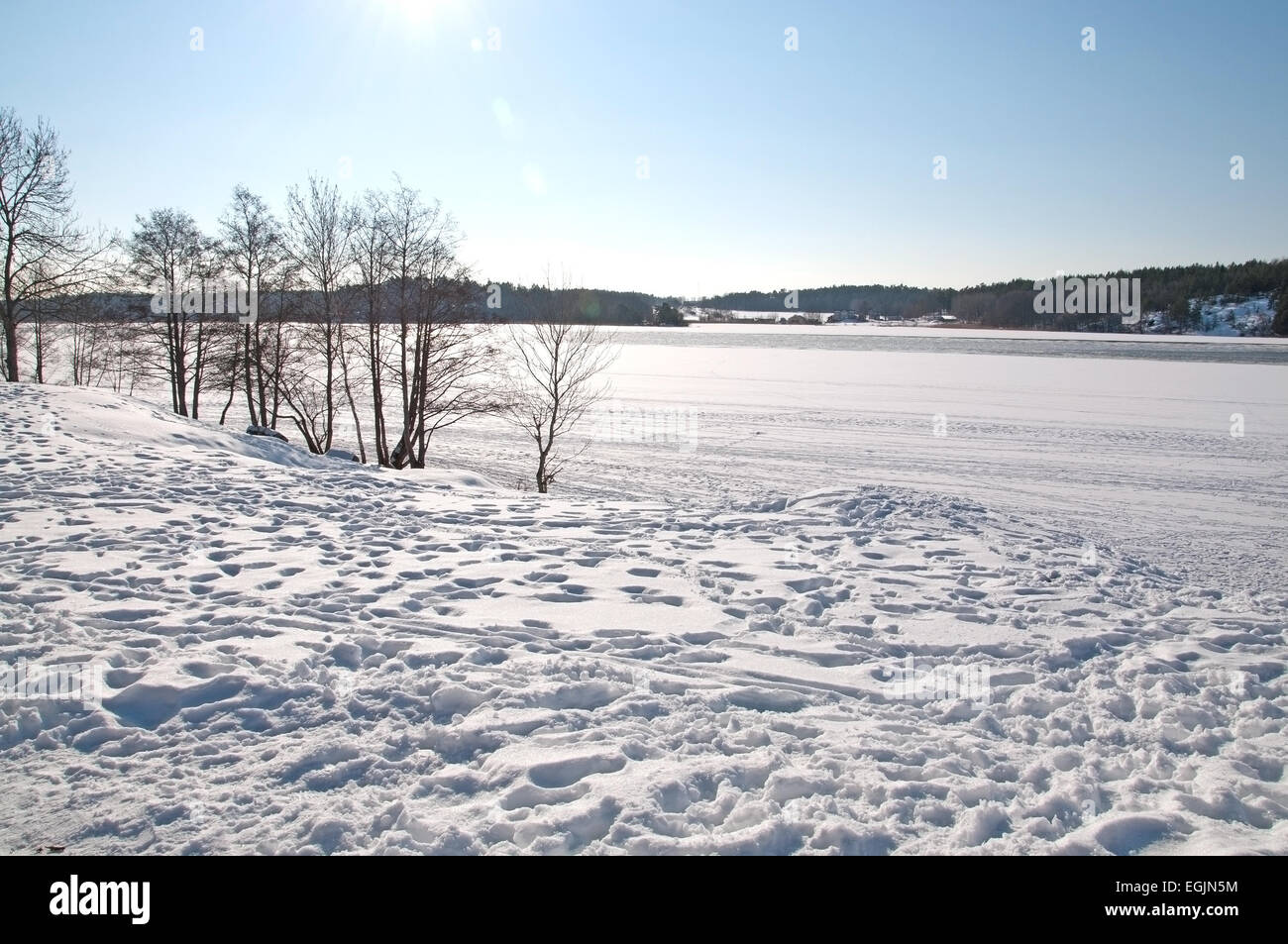 Schnee-Seenlandschaft mit tierischen oder menschlichen Spuren an einem sonnigen Tag, Stockholm, Schweden. Stockfoto