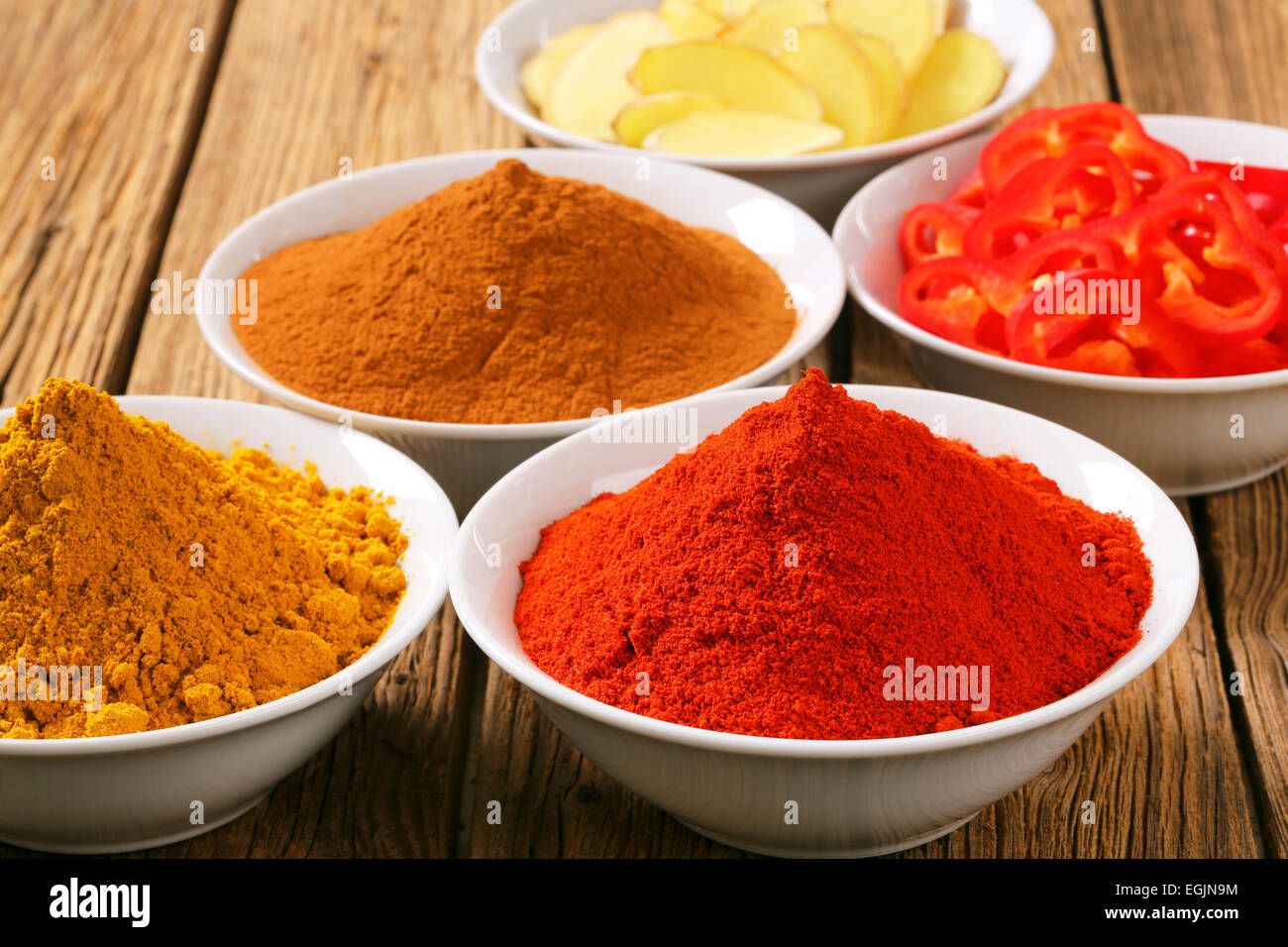 Schalen mit Currypulver, Paprikapulver, gemahlener Zimt, in Scheiben geschnitten, Ingwer und Paprika Stockfoto