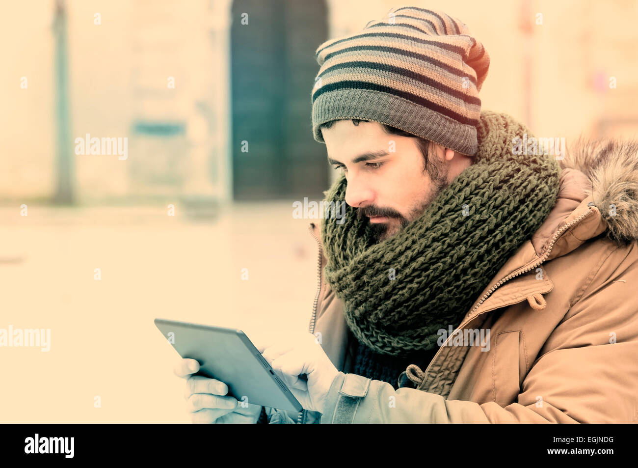 Hipster junge während der Verwendung einer Tabletts in städtischen Gebieten in Instagram Tönen Stockfoto