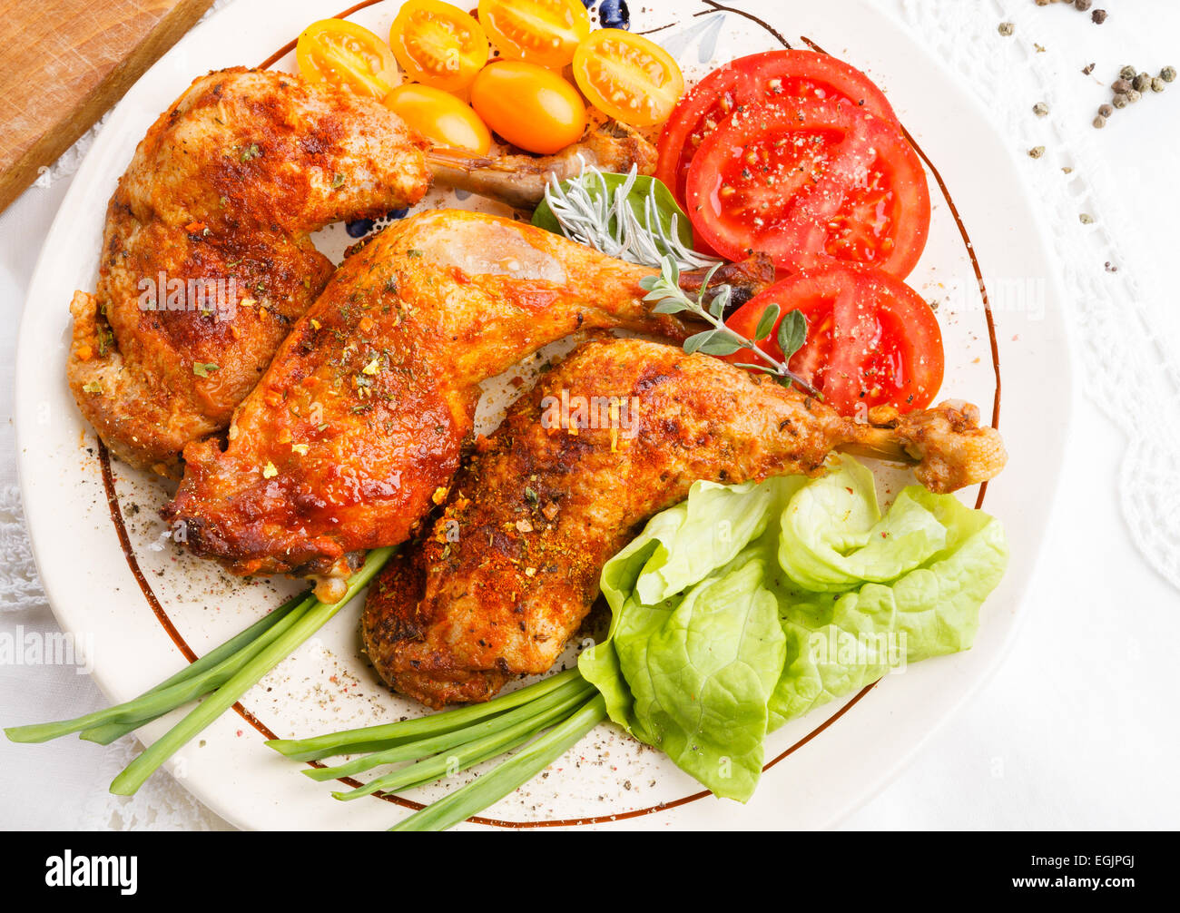 Nahaufnahme von Braten Türkei Beine Wit Tomaten Salat Kräuter auf weißes Tischtuch, Ansicht von oben Stockfoto