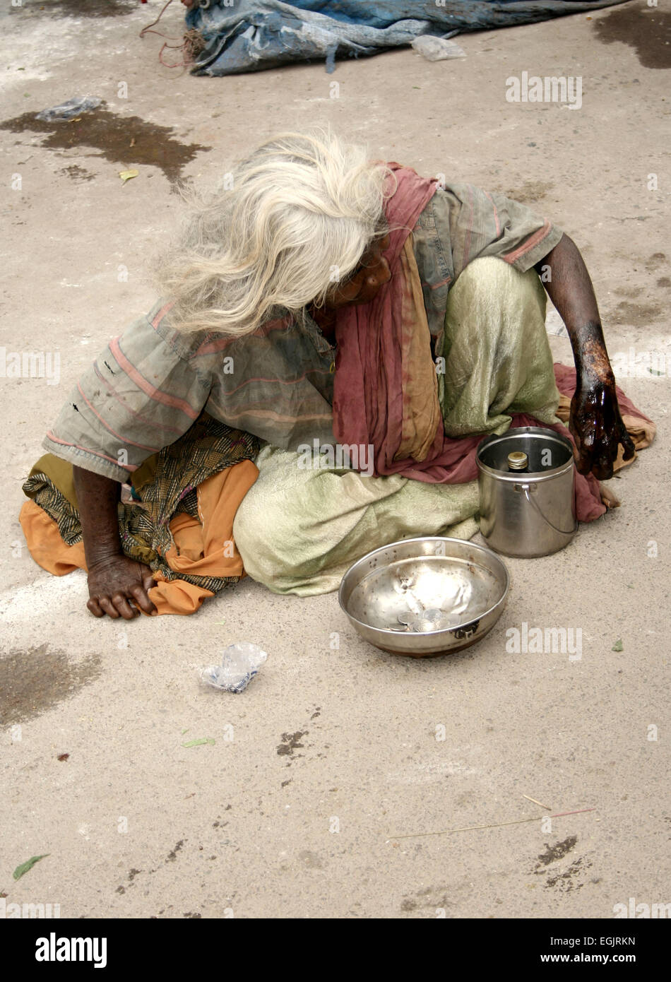 Alten Indianerin Hilfesuchenden auf einer viel befahrenen Straße OnJuly 28,2013 in Hyderabad, AP, Indien. Stockfoto