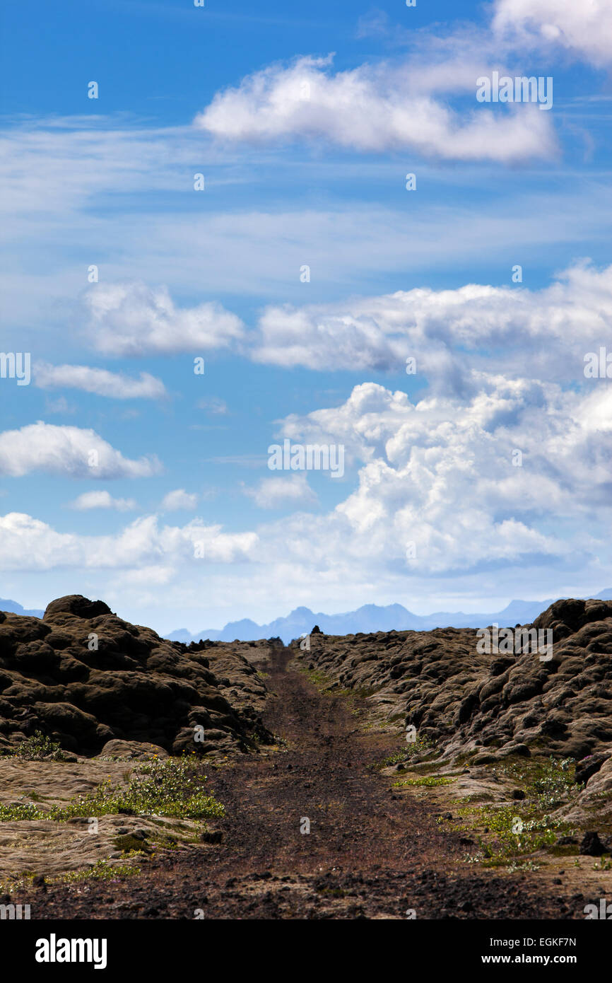 Eine unbefestigte Straße durch ein Lavafeld in Island, in Richtung Gletscher Mýrdalsjökull und Vulkan Katla. Stockfoto