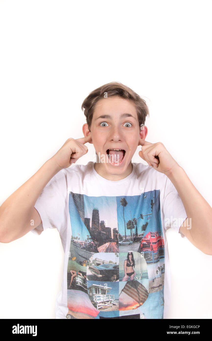 Weiße Teenager mit seinen Fingern in den Ohren schauen schockiert. Studioaufnahme Stockfoto