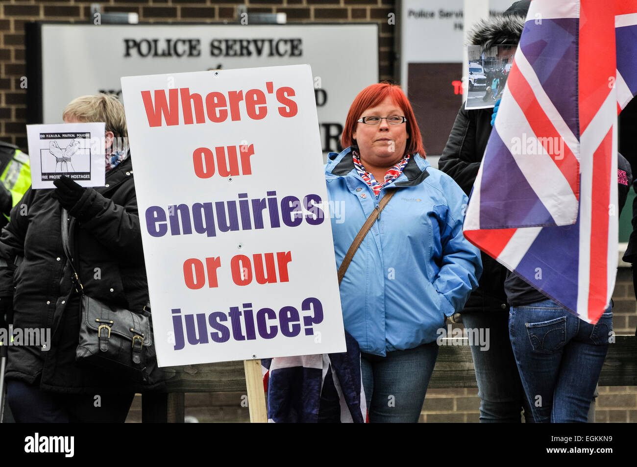 23.02.2013, Belfast, Nordirland. Frau hält ein Banner Sprichwort: "Wo ist [sic] unsere Anfragen oder unsere Gerechtigkeit?" während einer Flagge Protestaktion vor PSNI Sitz, nach Vorwürfen von Polizeibrutalität bei früheren Protesten. Stockfoto