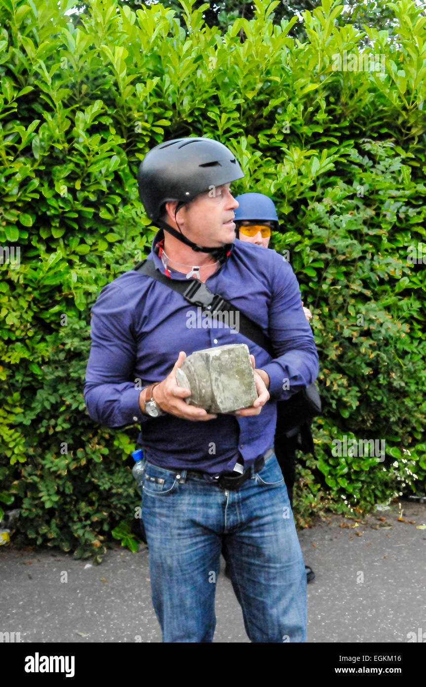Belfast, Nordirland. 12. Juli 2013 - hebt Ross Kemp ein großes Stück Beton, die während eines Aufstandes in Belfast geworfen worden war Stockfoto