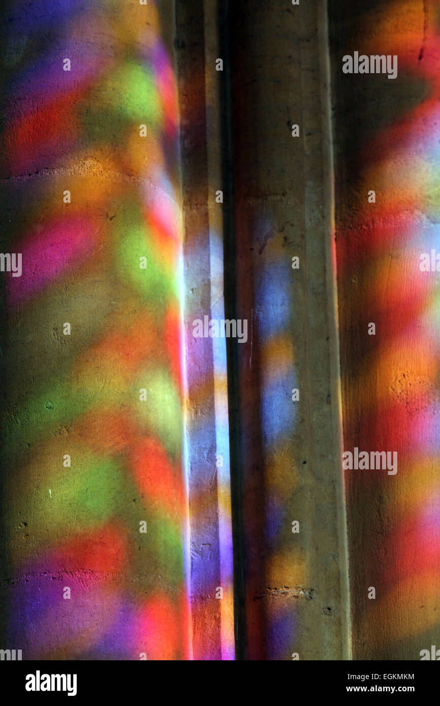 Psychedelische Farben farbiges Licht aus Buntglas-Fenster projiziert auf Säule innerhalb der Sagrada Familia Stockfoto