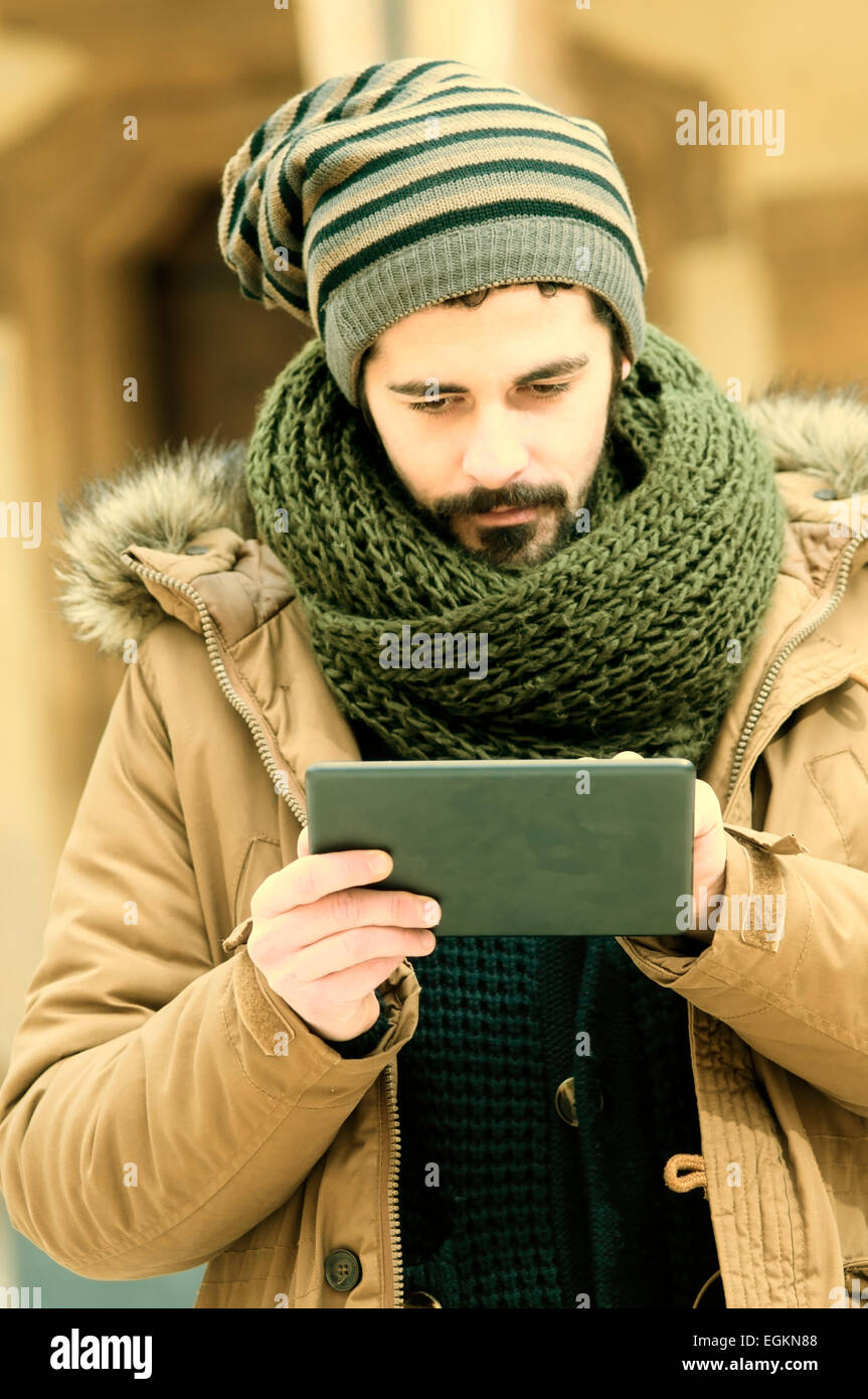 Hipster junge während der Verwendung einer Tabletts in städtischen Gebieten in Instagram Tönen Stockfoto