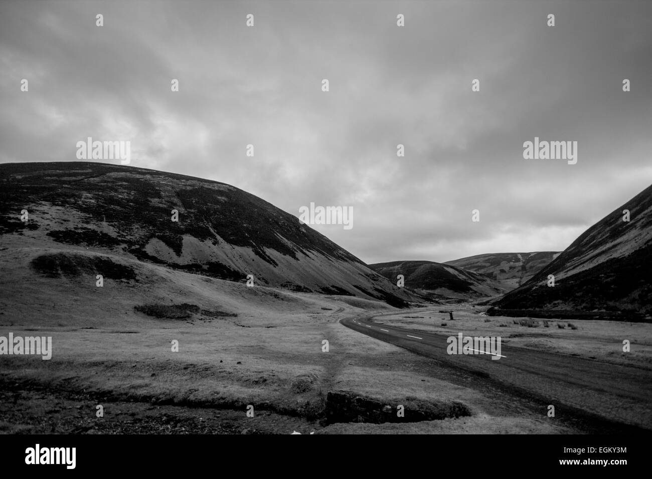 Ein schwarz-weiß Foto von der Landstraße durch Hügel Schottland, UK Stockfoto