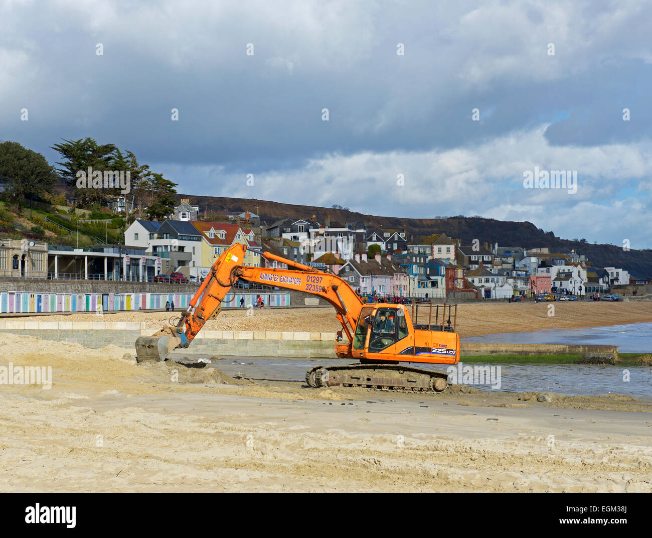Nivellierung des Strands bei Lyme Regis mit einem JCB Bagger, Dorset, England UK Stockfoto