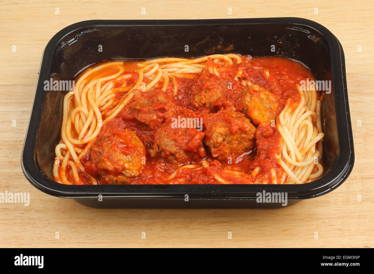 Spaghetti und Fleischbällchen in einem Kunststoff Karton auf einem Holzbrett Stockfoto