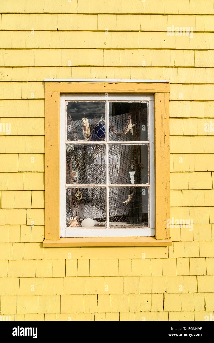 Malerische altes Fenster dekoriert in einem nautischen Thema mit Fischnetz, Muscheln, Seesterne und andere Dinge aus dem Meer. Stockfoto