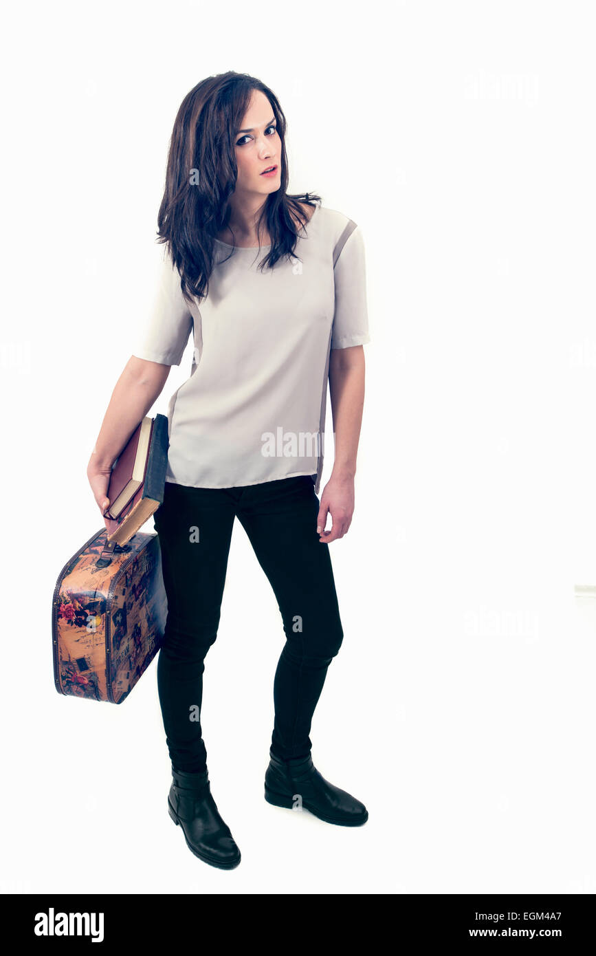 Schöne junge Frau in den Urlaub mit einem Koffer und Bücher Stockfoto